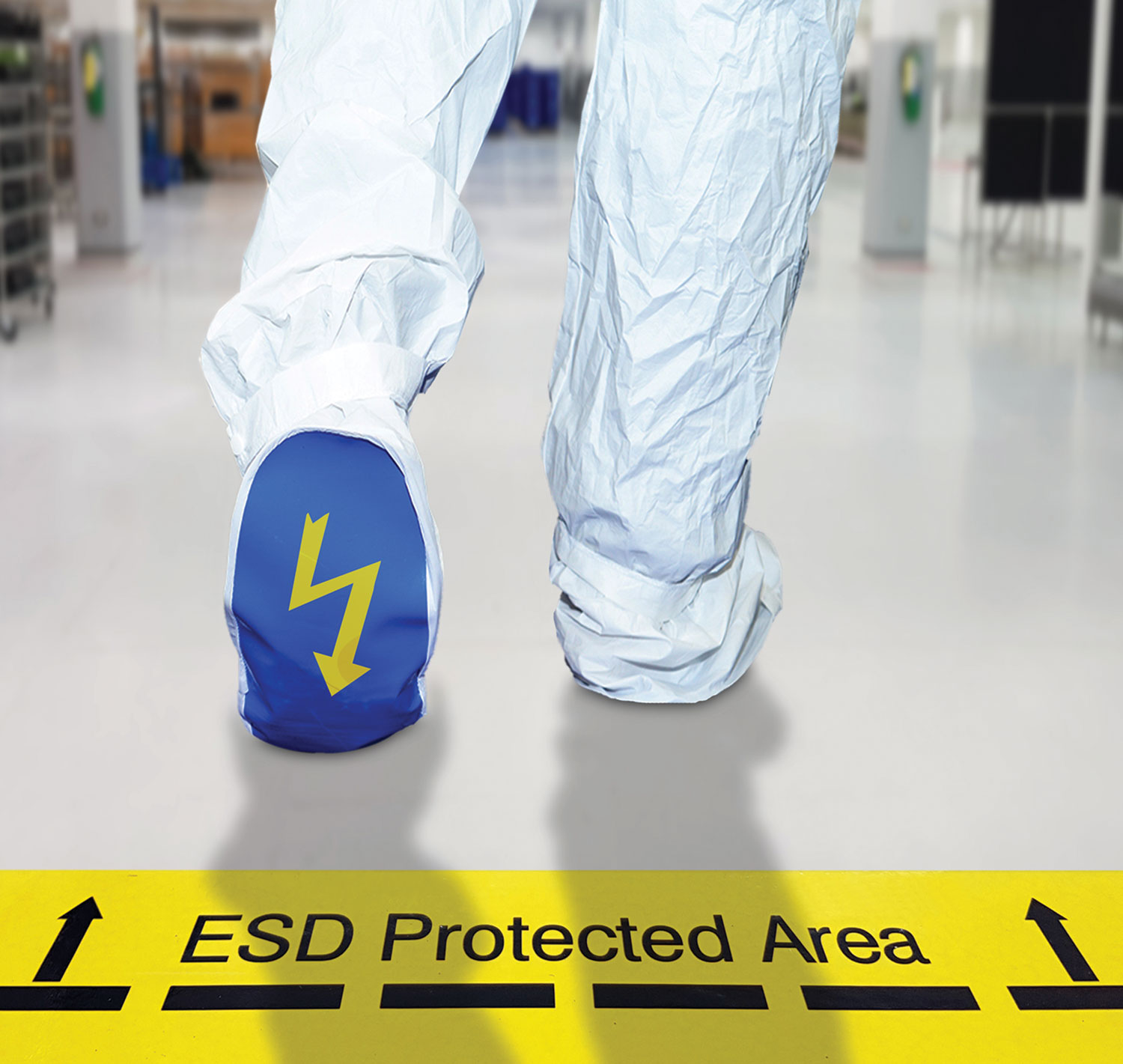 worker wearing static suit walking over floor signage reading "ESD Protected Area"