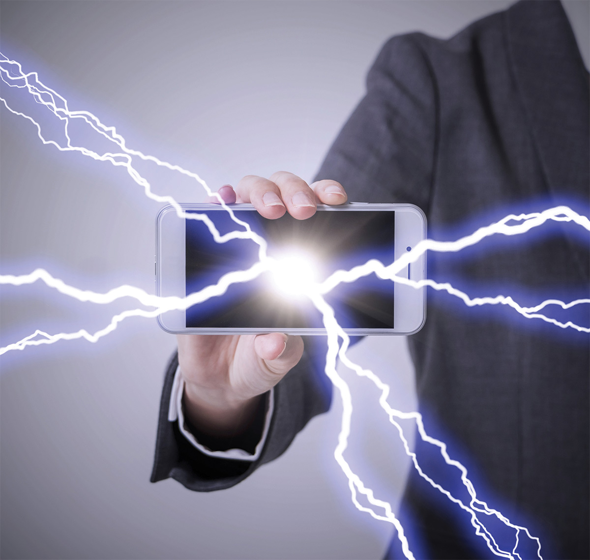 man with cell phone in hands with electricity coming out of it
