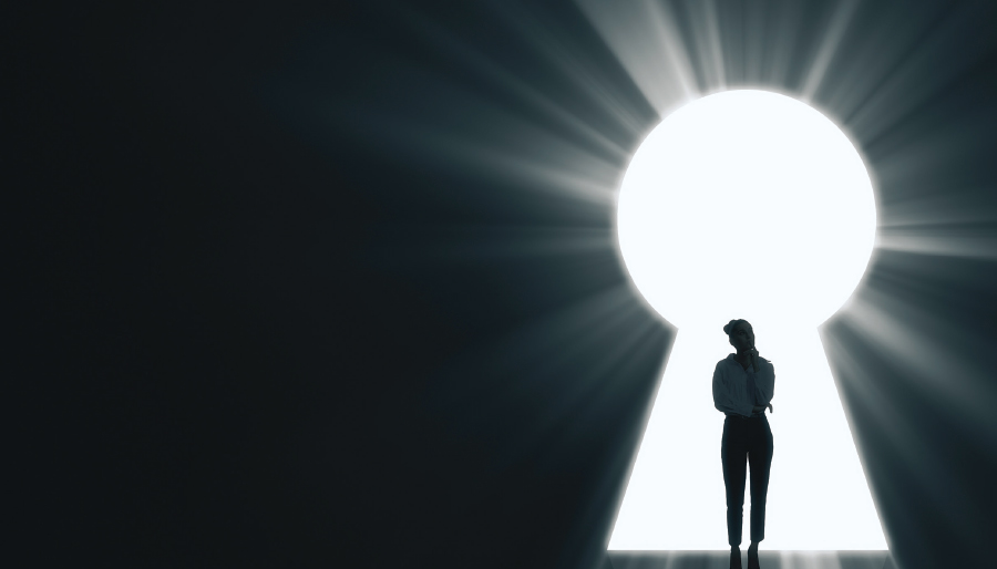 silhouette of woman in light coming through a keyhole