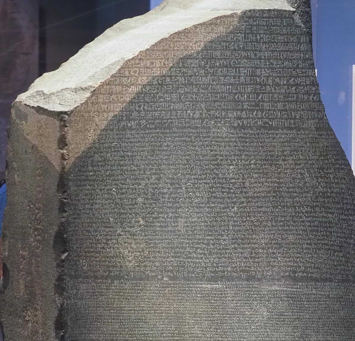 close up of the Rosetta Stone stele at the British Museum with text in Ancient Egyptian hieroglyphic, Demotic scripts and Ancient Greek