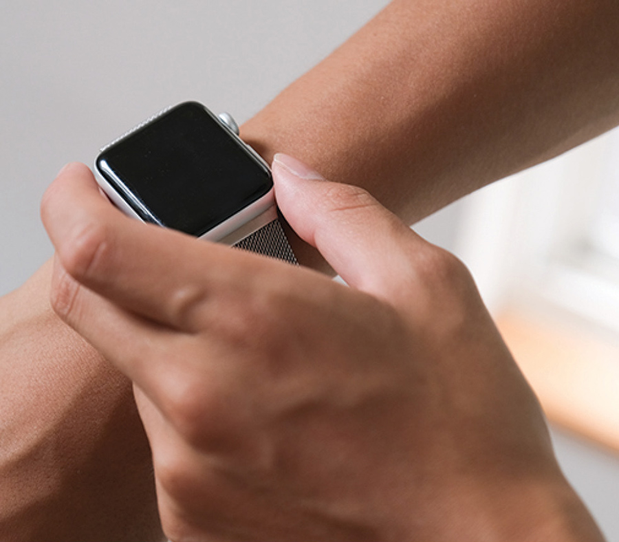 Apple watch around someone's wrist while they reach to use it with their other hand