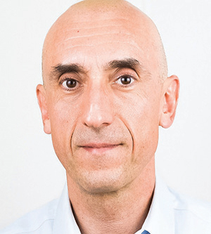 Headshot of a bald man wearing a white shirt