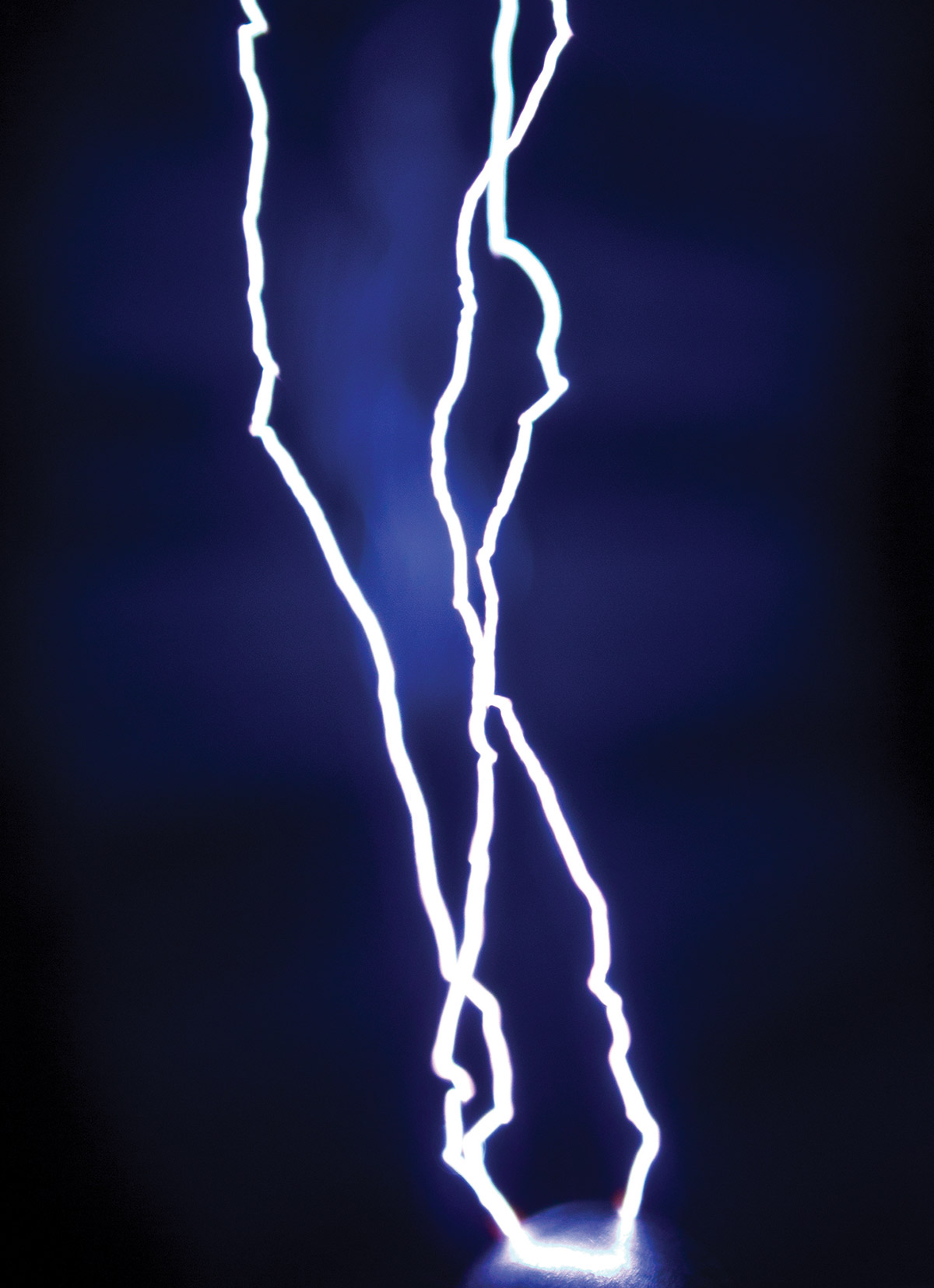 Electricity against a dark blue background, looks like lightning against a dark sky 