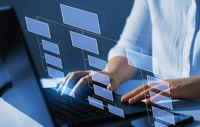 person typing on laptop with a digital branching diagram overlay