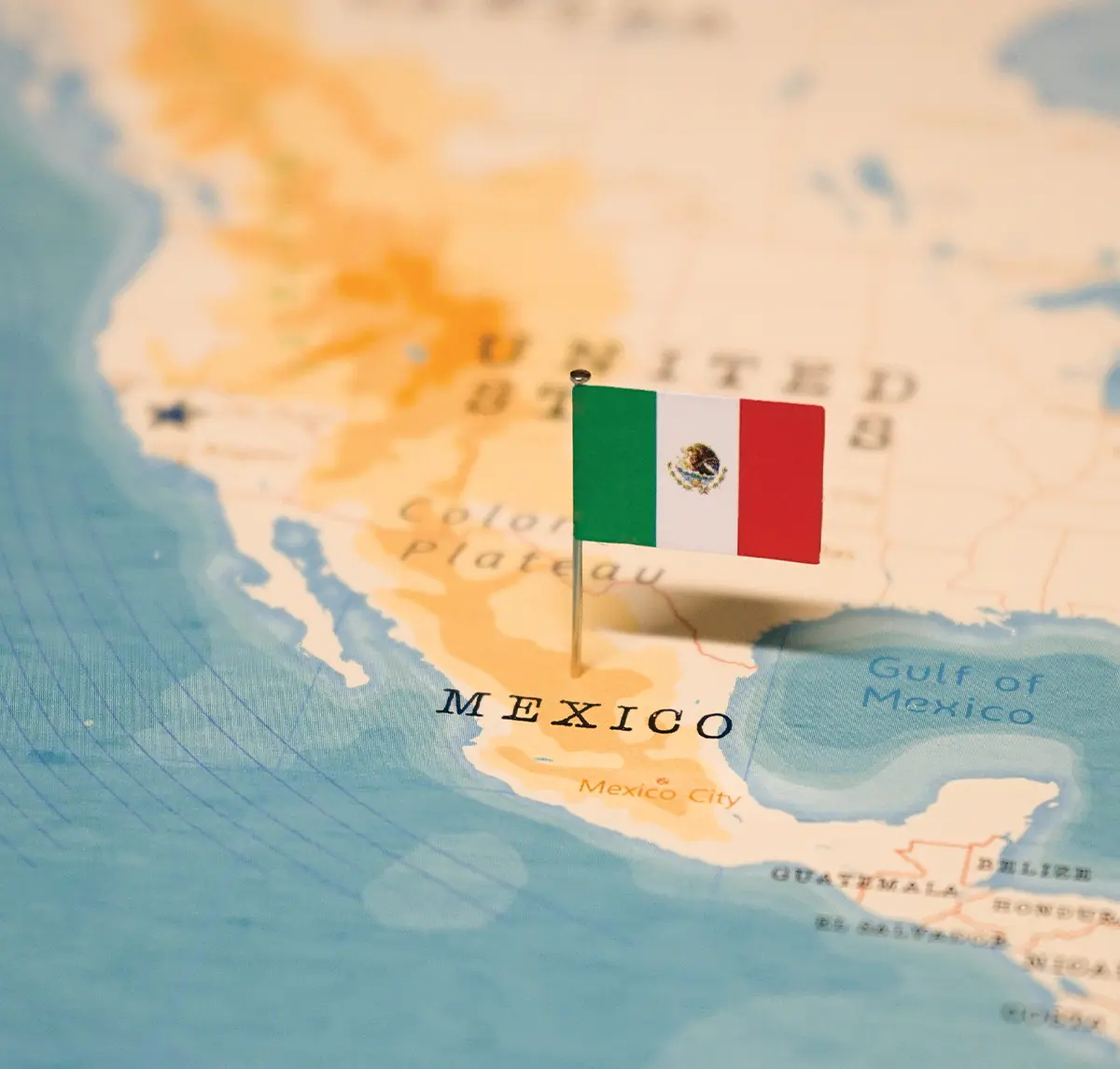 zoomed in view of a map of north America with a focus on Mexico, a pin with the Mexican flag placed in the middle of the country