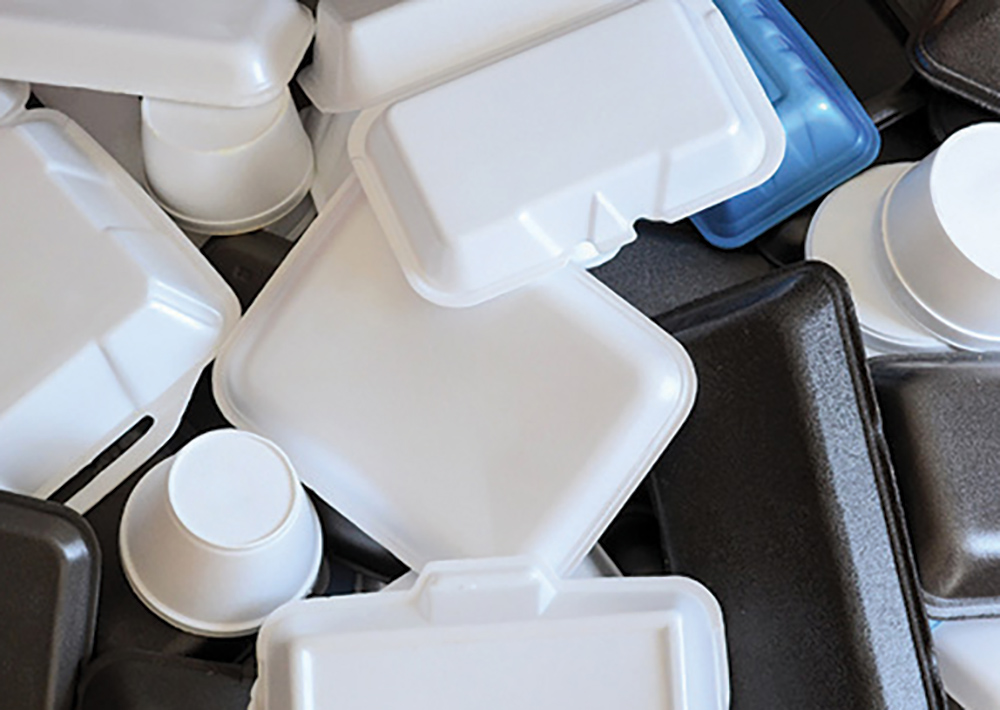 A variety of styrofoam plastic containers in different colored shapes such as white, black, and blue of many different sizes all displayed bundled up together