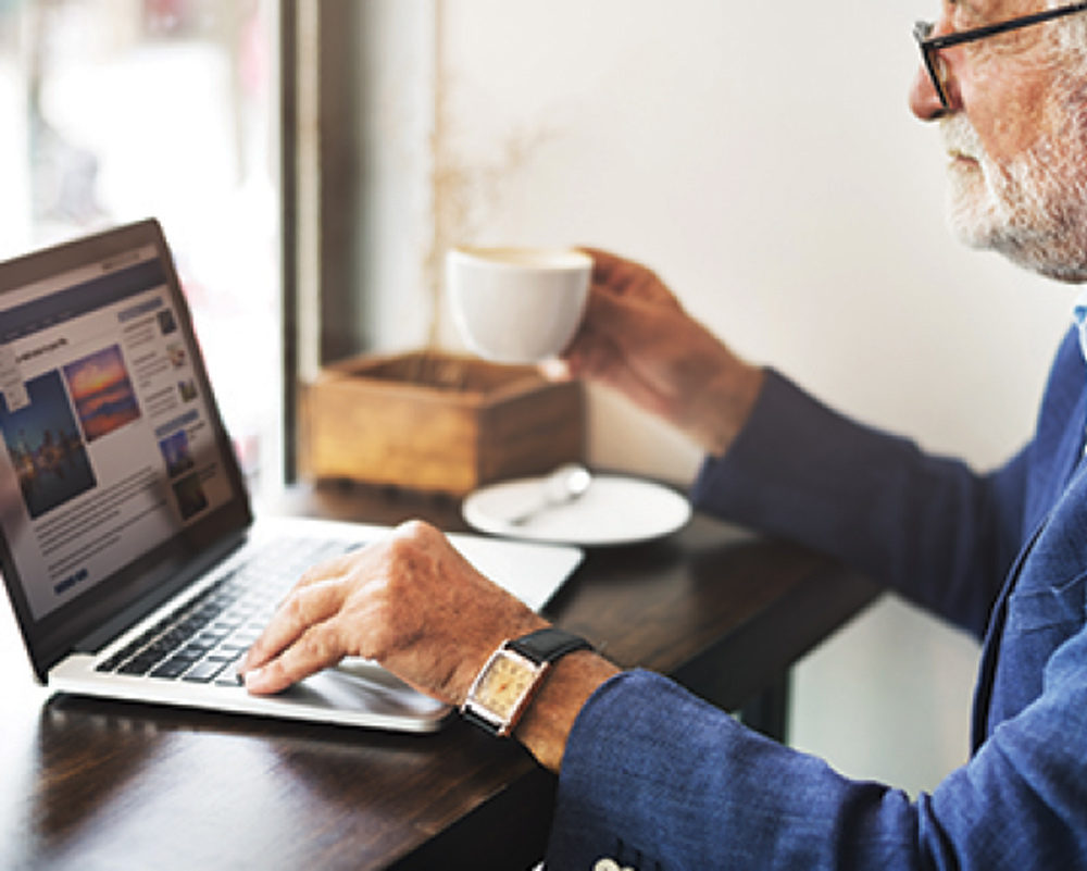 man sitting at a desk using a laptop