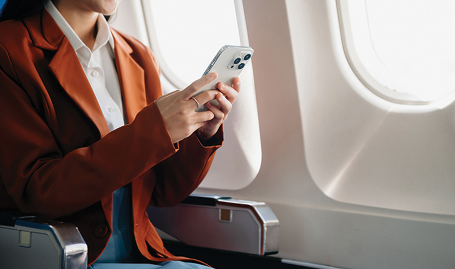 woman sitting on a plane using her phone