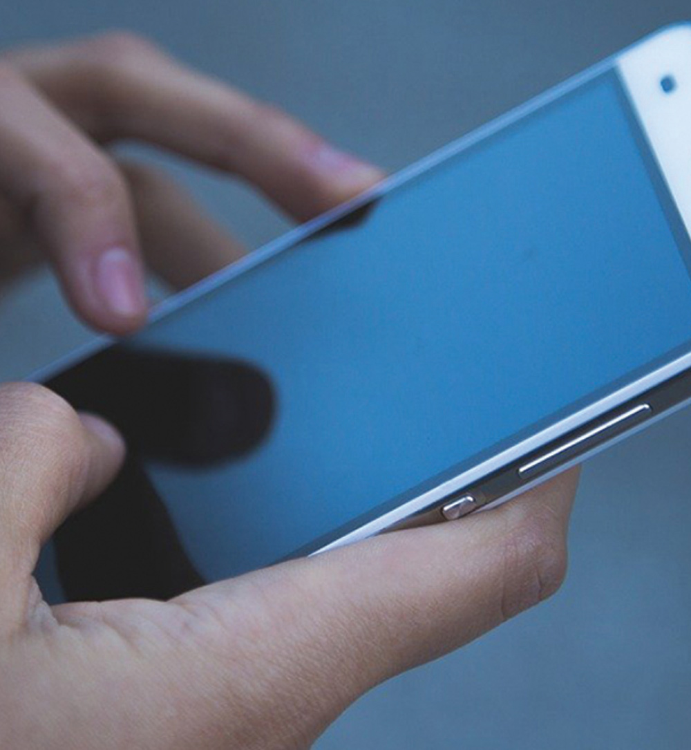 Close-up of hands holding a smartphone horizontally.