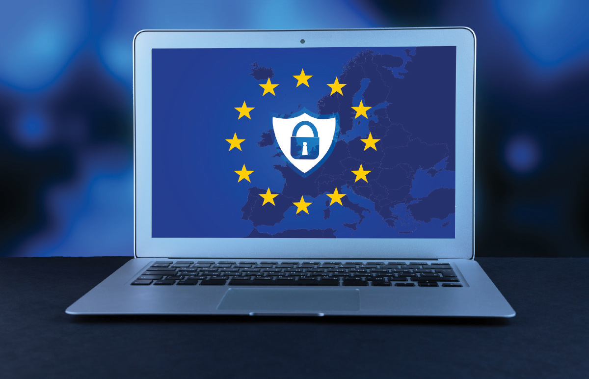 A front-facing, eye-level shot of an open laptop screen displaying a map of Europe within a circle of 12 yellow stars, the flag of the European Union. 