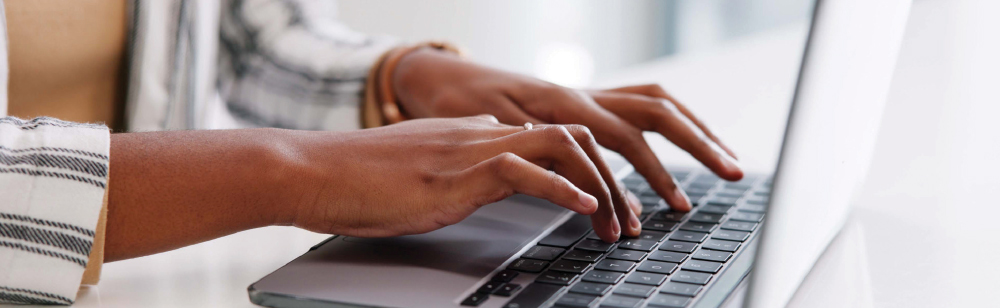 Cropped image of hands typing on a laptop.