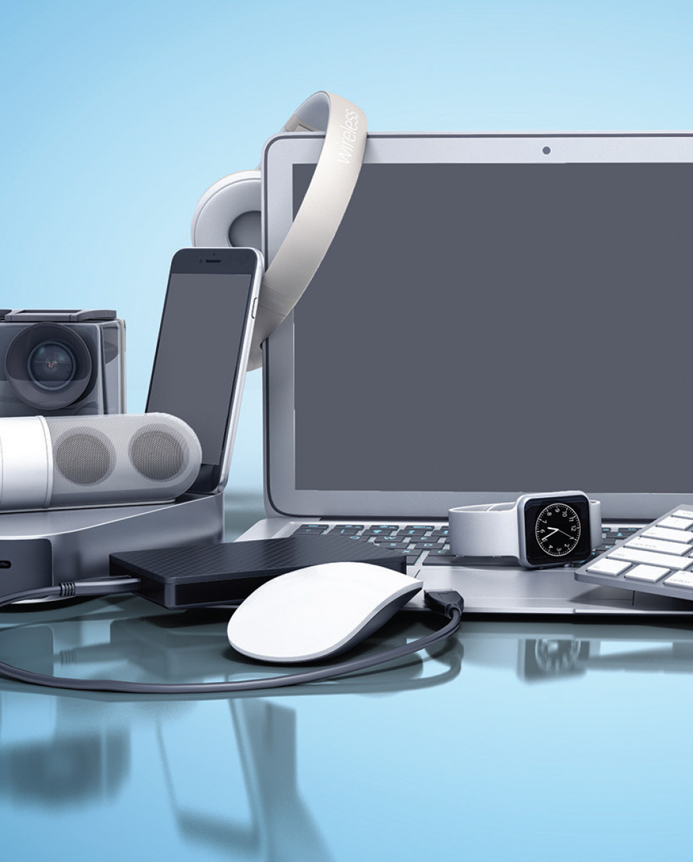 an organized pile of technology devices including a computer drives, a monitor, a smartphone, digital cameras, a tablet, bluetooth headphones, a small portable speaker, a keyboard, a computer mouse and a smart watch