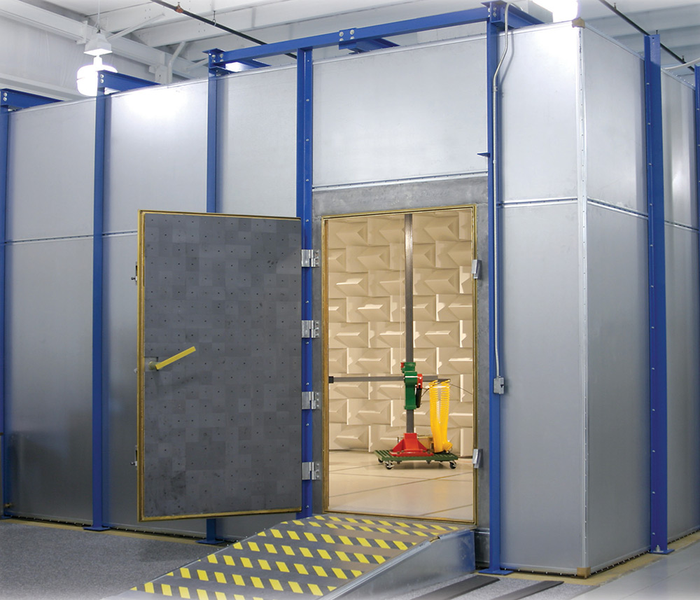 Open RF-shielded door leading into an anechoic test chamber with wall absorber panels.